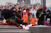 Persone depongono fiori in un monumento spontaneo in memoria delle vittime dell'attentato di Mosca a San Pietroburgo, Russia, domenica 24 marzo 2024. 