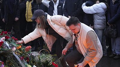 مواطنون روس يضعون الزهور على نصب تذكاري مؤقت لضحايا هجوم موسكو الذي وقع في 22 مارس / آذار 2024