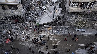 Los palestinos inspeccionan los daños a los edificios residenciales después de un ataque aéreo israelí en Rafah, en el sur de la Franja de Gaza, el domingo 24 de marzo de 2024