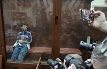 Dalerdzhon Mirzoyev, a suspect in the Crocus City Hall shooting on Friday sits in a glass cage in the Basmanny District Court in Moscow, Russia, Sunday, March 24, 2024.