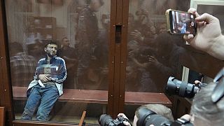 Dalerdzhon Mirzoyev, a suspect in the Crocus City Hall shooting on Friday sits in a glass cage in the Basmanny District Court in Moscow, Russia, Sunday, March 24, 2024.