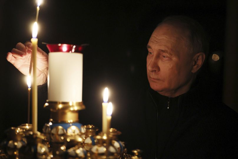 Putin lights a candle to commemorate the victims of an attack on the Crocus City Hall concert venue, on the day of national mourning, in Russia, Sunday, March 24, 2024.