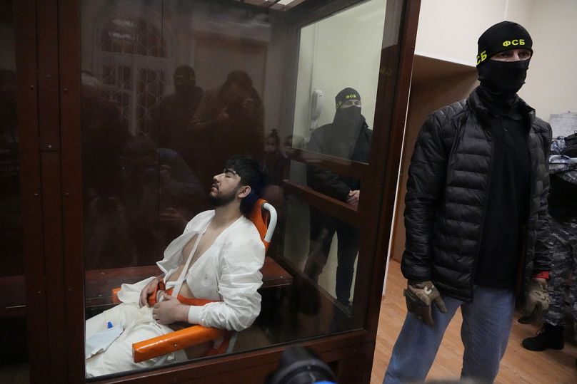 Der Angeklagte Mukhammadsobir Faizov sitzt in einem Rollstuhl in einem Glaskäfig im Gerichtssaal