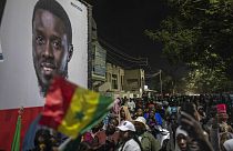 Simpatizantes del candidato Bassirou Diomaye Faye se reúnen frente a su sede de campaña mientras esperan los resultados de las elecciones presidenciales, en Dakar, Senegal.