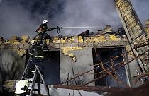 Des pompiers ukrainiens tentent d'éteindre un incendie causé par des missiles de l'armée russe
