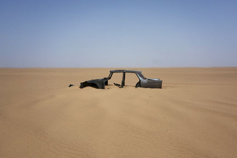 The frame of an abandoned Peugeot 404 rests in the south central Sahara, June 2018
