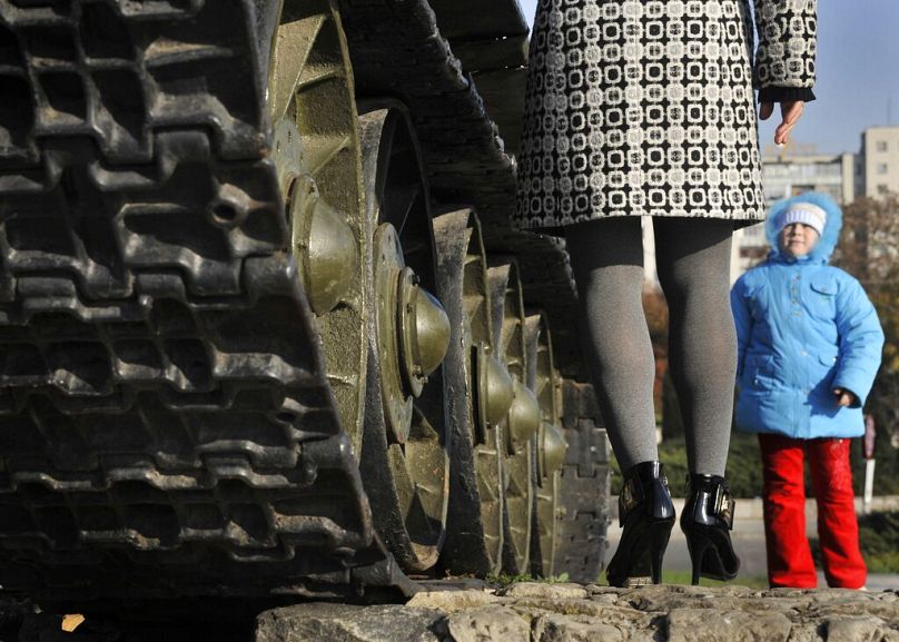 A mother and her child play around a WWII memorial tank in Tiraspol, in Transnistria, November 2008