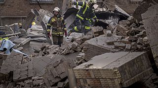 Ukrainische Ersthelfer gehen in den Trümmern eines Gebäudes im Stadtteil Pecherskyi nach einem russischen Luftangriff in Kiew, Ukraine, am Montag, 25. März 2024. 