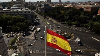 A Spanish flag waves above the Cibeles square close to Spain's Bank, left, seen from a balcony of Madrid's city hall, in Madrid, Spain.