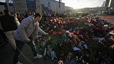 Emberek virágot helyeznek el egy rögtönzött emlékműnél a városháza előtt Moszkva nyugati külvárosában, Oroszországban, 2024. március 25-én, hétfőn.