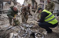 Ukrán katonai szakértők egy rakéta maradványait gyűjtik egy lerombolt épület mellett a Pecserszkij kerületben, egy orosz légitámadás után az ukrajnai Kijevben 2024. március 25