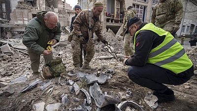 Esperti militari ucraini raccolgono i resti di un missile accanto a un edificio distrutto nel quartiere Pecherskyi, dopo un attacco aereo russo a Kiev, Ucraina, 25 marzo 2024