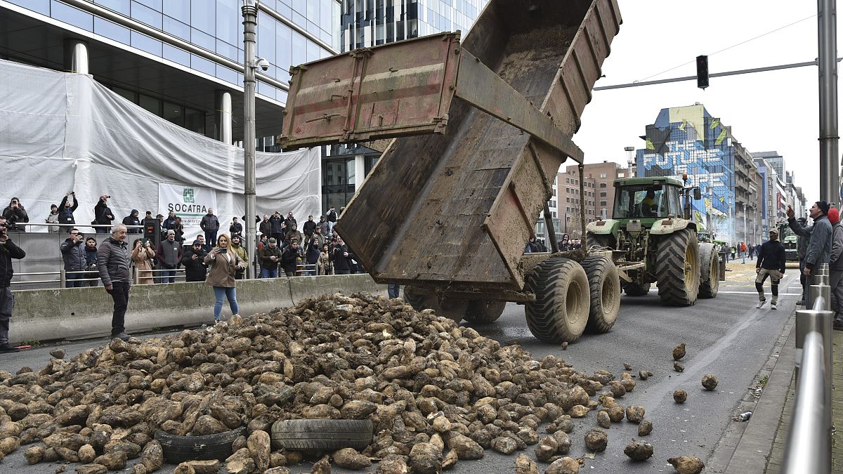 المزارعون المحتجون يلقون حمولة من البطاطس في شارع رئيسي خلال مظاهرة خارج مبنى المجلس الأوروبي في بروكسل، الثلاثاء، 26 مارس 