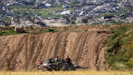 Israeli soldiers rest on top of their tank on the border with the Gaza Strip, in southern Israel, Tuesday, March 26, 2024.