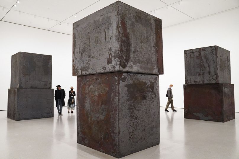 Guests browse Richard Serra's "Equal" at the Museum of Modern Art in the new fall exhibition spaces, 13 November 2020, in New York.