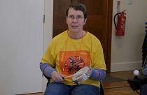 A woman in a samba drum class for people with Parkinson's disease.