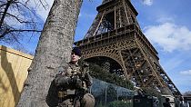 Ein Soldat patrouilliert am Montag, 25. März 2024, am Eiffelturm in Paris.