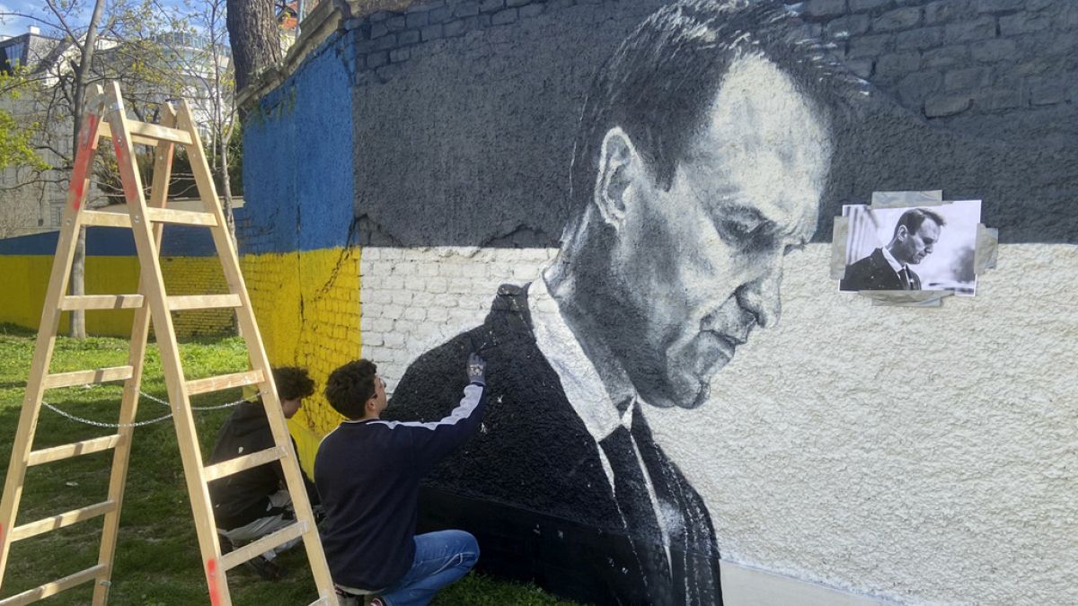 Des artistes peignent à la bombe des portraits d’Alexeï Navalny derrière un monument soviétique à Vienne