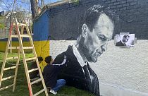 Austrian graffiti duo Joel Gamnou paint a picture of Alexei Navalny on a wall in Vienna, Austria, Wednesday, 27 March 2024.