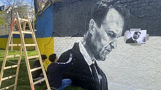 Austrian graffiti duo Joel Gamnou paint a picture of Alexei Navalny on a wall in Vienna, Austria, Wednesday, 27 March 2024.