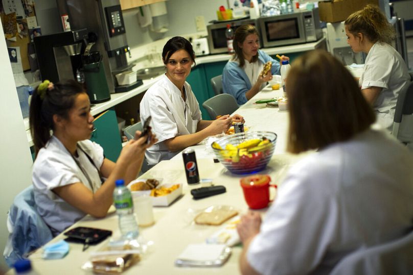 A nurse talks to colleagues during a dinner break in the intensive care ward for COVID-19 patients at a hospital in Liege, December 2020