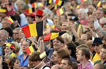 People wave Belgian flags as royal family members arrive outside of the national ball in the Marolles district of Brussels on Saturday, July 20, 2013.
