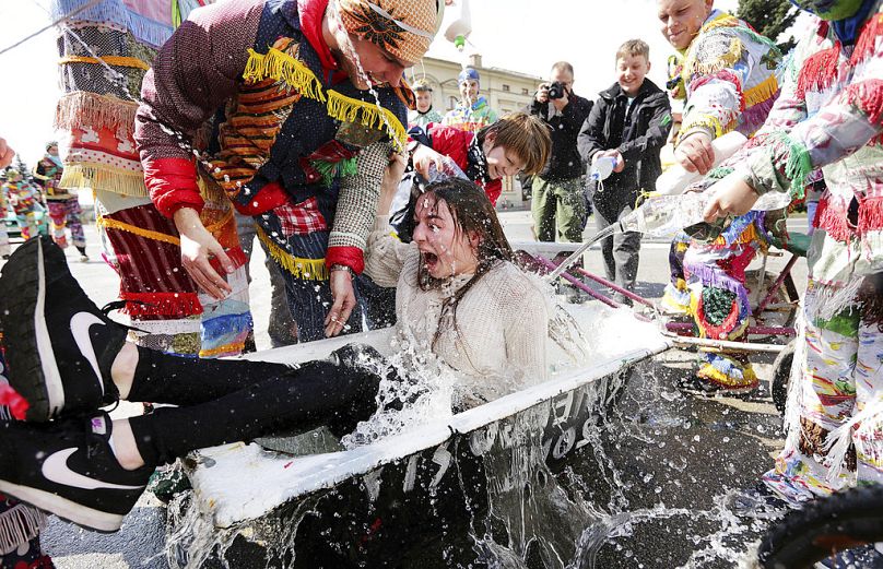A girl is splashed with water by boys following a Polish Wet Easter Monday tradition, in Wilamowice, Poland, Monday, 17 April 2017.