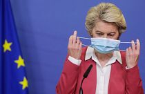 Председатель Европейской комиссии Урсула фон дер Ляйен снимает защитную маску, готовясь выступить с заявлением в штаб-квартире ЕС в Брюсселе, 2021 июля.