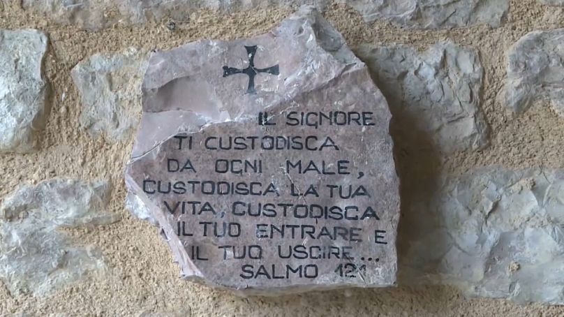 Imagen de las palabras de un salmo bíblico escrito en una piedra, en una de las paredes de la Abadía de San Benito.