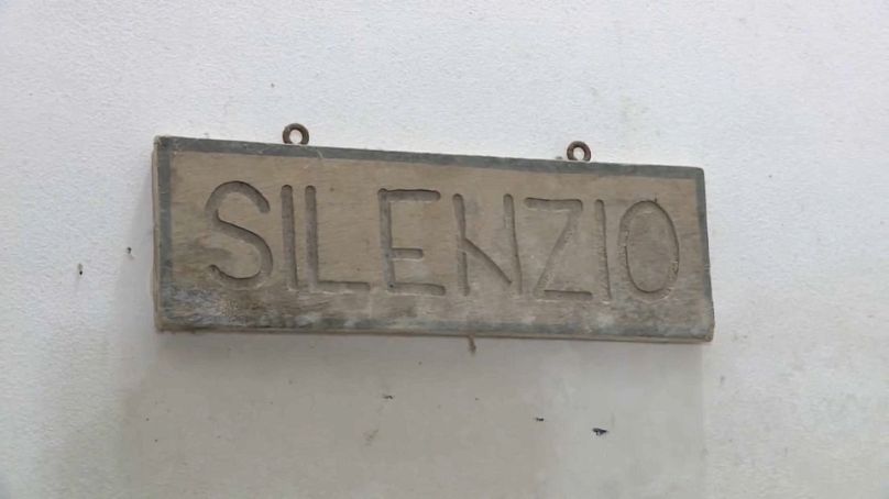 Auf einer Wand der Abtei hängt eine Aufschrift mit dem Wort "Stille".