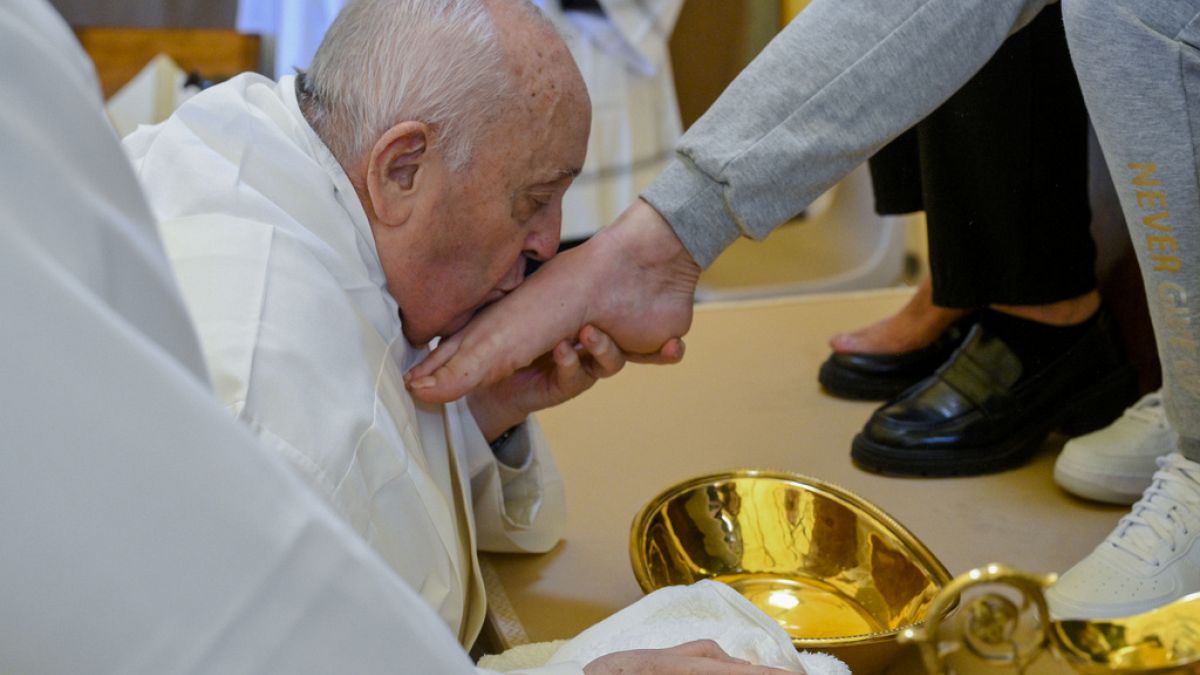 In this image made available by Vatican Media, Pope Francis kisses the foot of a woman inmate of the Rebibbia prison on the outskirts of Rome on Holy Thursday, March 28, 2024,