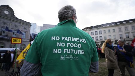 Um agricultor usa uma t-shirt com uma mensagem durante uma manifestação de agricultores franceses e belgas em frente ao Parlamento Europeu, em Bruxelas, a 24 de janeiro.