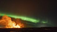 Volcán en erupción con la auroraboreal de fondo cerca de Grindavik