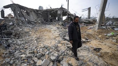 فلسطيني يمشي على أنقاض منزله المدمر جراء قصف إسرائيلي في رفح - غزة. 2024/03/26
