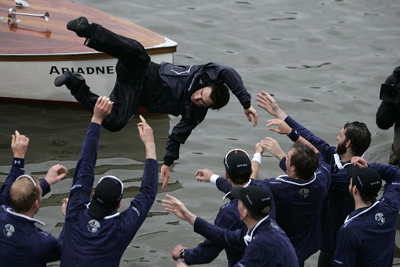 Members of the Oxford University rowing team throw their cox Nicholas Brodie, centre, into the river after beating Cambridge University, in 2008