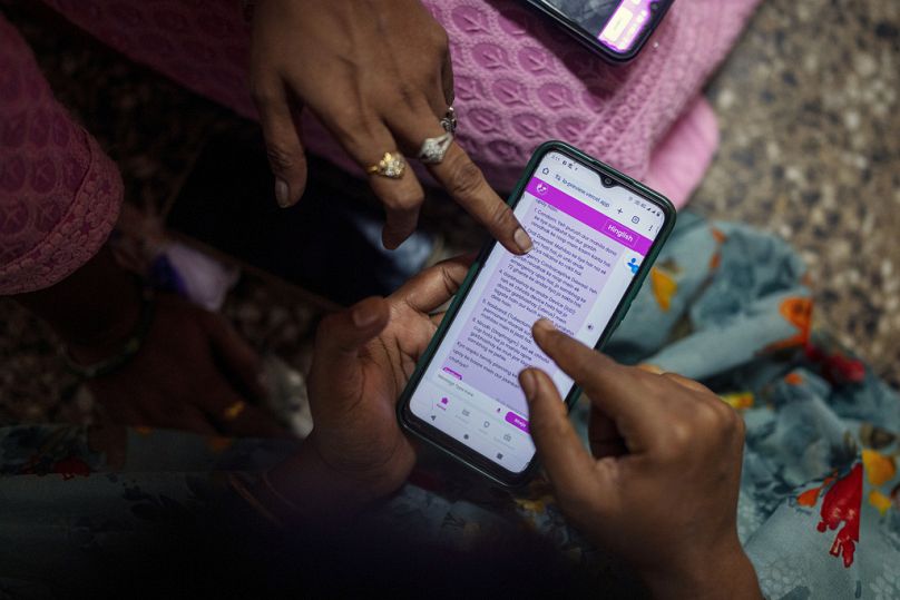 Women learn to use a chatbot powered by artificial intelligence at the local women's organization’s office in Mumbai, February 2024
