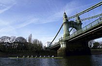 The Cambridge men's team pass under Hammersmith Bridge during a training session on the River Thames in London on Tuesday