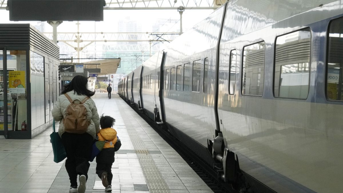 Seul tren istasyonunda yürüyen bir kadın ve bir çocuk