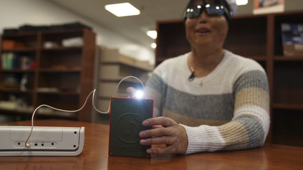 Minh Ha, Manager für Hilfsmittel an der Perkins School for the Blind, probiert zum ersten Mal ein LightSound-Gerät aus.