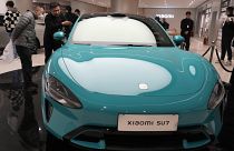Visitors to the Xiaomi Automobile flagship store look at the Xiaomi SU7 electric car on display in Beijing, Tuesday, March 26, 2024.