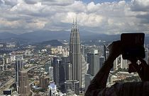 Petronas Kuleleri'nden Kuala Lumpur'un fotoğrafını çeken bir kişi 
