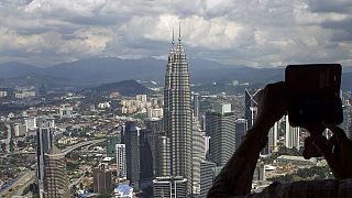 Petronas Kuleleri'nden Kuala Lumpur'un fotoğrafını çeken bir kişi 