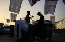 People walk under campaign banners of candidates for Istanbul of Justice and Development Party, or AKP, and Republican People's Party, or CHP, in Istanbul
