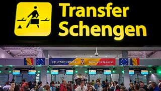 Passengers arriving at the Henri Coanda International Airport pass under a Schengen Information sign, in Otopeni, near Bucharest, Romania, Sunday, March 31, 2024. 