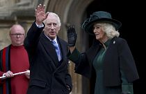 Britain's King Charles III, center, and Queen Camilla wave as they arrive to attend the Easter Matins Service at St. George's Chapel, Windsor