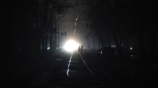 People cross the road at the city center which lost electrical power after yesterday's Russian rocket attack in Kyiv, Ukraine, Thursday, Nov. 24, 2022.