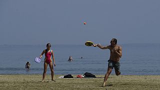 A man and woman play racketball on the beach during a hot day in southern coastal city of Larnaca on the Mediterranean island of Cyprus, Sunday, 31 March 2024