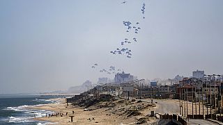 An aircraft airdrops humanitarian aid over the northern Gaza Strip, as seen from central Gaza, Monday, April 1, 2024.