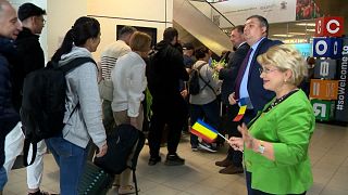 Des voyageurs passent sous des panneaux orientant vers des couloirs Schengen et non-Schengen, le 31 mars 2024, à l'aéroport d'Otopeni.