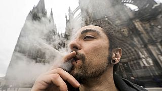 Un hombre fuma cánnabis frente a la Catedral de Colonia, Alemania, en un acto de consumo público tras el inicio de una nueva ley el lunes 1 de abril de 2024.